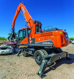 Develon DX225MH-5 material handler picking up a car. Develon DX225MH-5 material handler picking up a car.