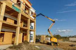 JCB boom lift reaching up to the third story of a building. JCB boom lift reaching up to the third story of a building.