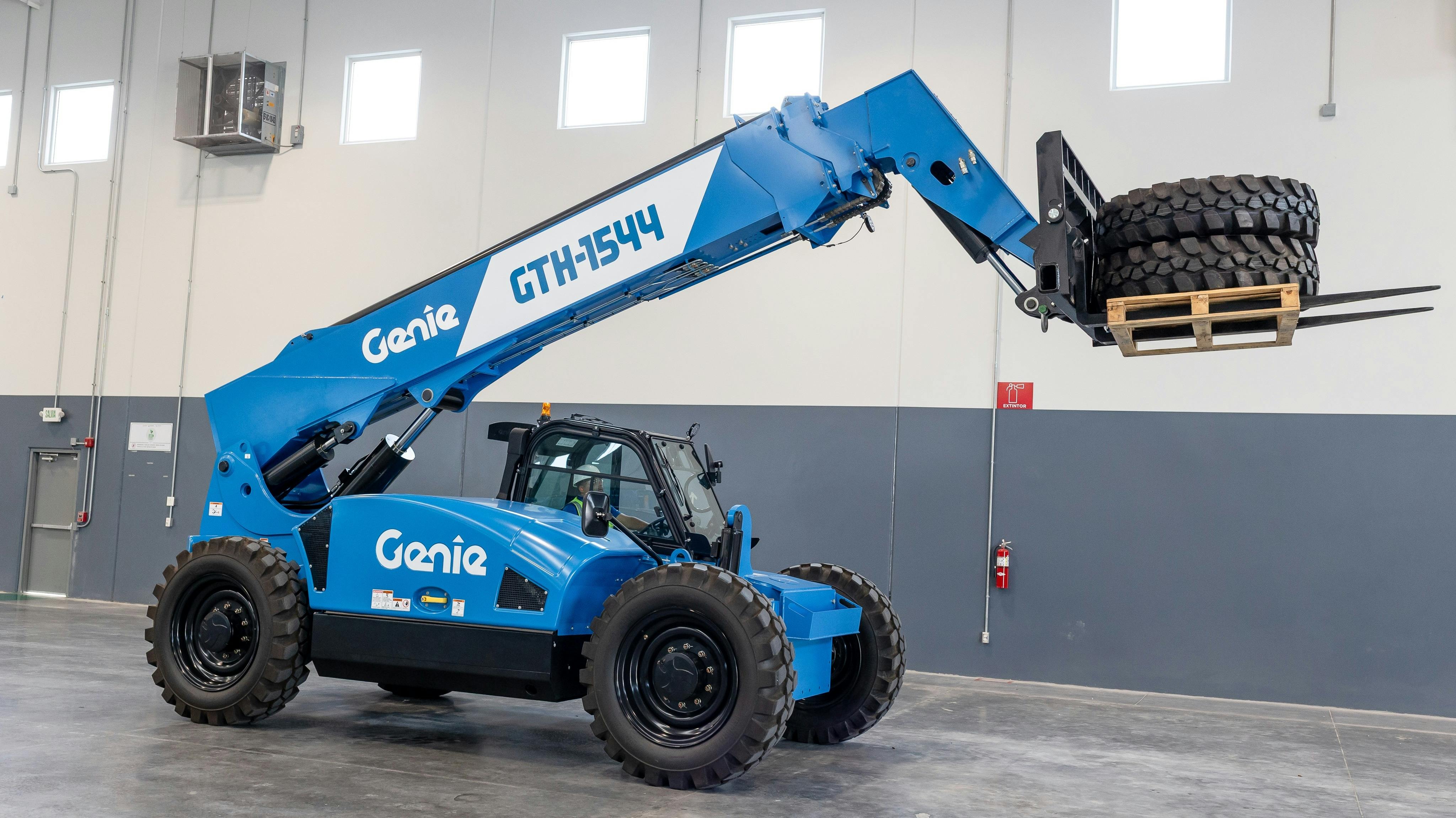 Genie GTH-1544 telehandler carrying tires with pallet forks.