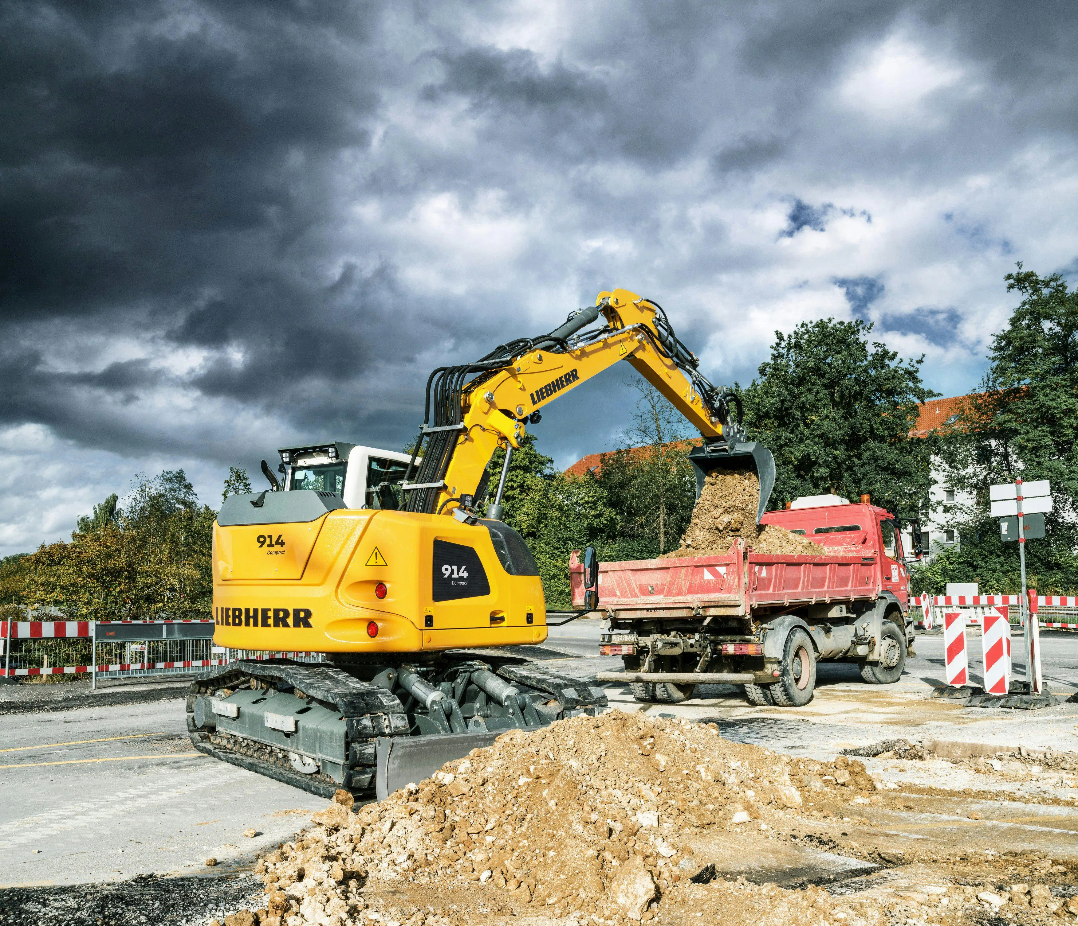 Liebherr R920 compact excavator dumping into a dump truck. Liebherr R920 compact excavator dumping into a dump truck.