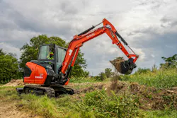 Kubota KX040-5 compact excavator digging dirt. Kubota KX040-5 compact excavator digging dirt.