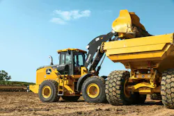 John Deere wheel loader dumping dirt into an ADT. John Deere wheel loader dumping dirt into an ADT.