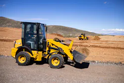 Caterpillar 903 compact wheel loader with a big wheel loader in the background.