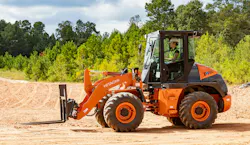 Hitachi compact wheel loader with a pair of pallet forks, ready to work.