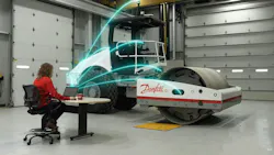 Aces roller with Danfoss logo. Woman on laptop shooting updates to roller.