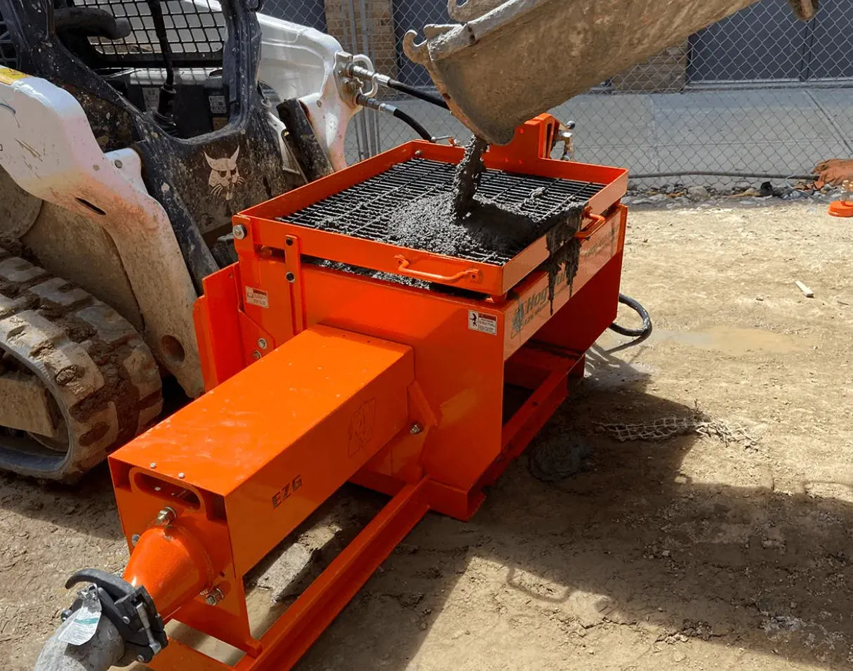 EZG hog pump filled with concrete, working off a Bobcat skid steer.
