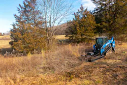 Blue Diamond heavy-duty brush cutter working on a compact track loader, cutting a field.