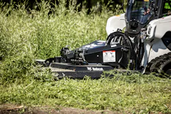 Bobcat Brushcat rotatory cutter attachment on a compact track loader, cutting a field.