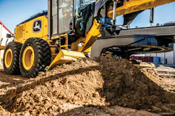 John Deere P-Tier motor grader blade pushing dirt.