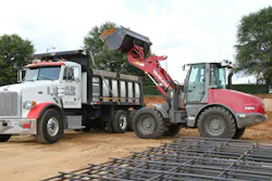 Takeuchi TW95 compact wheel loader loading a truck.