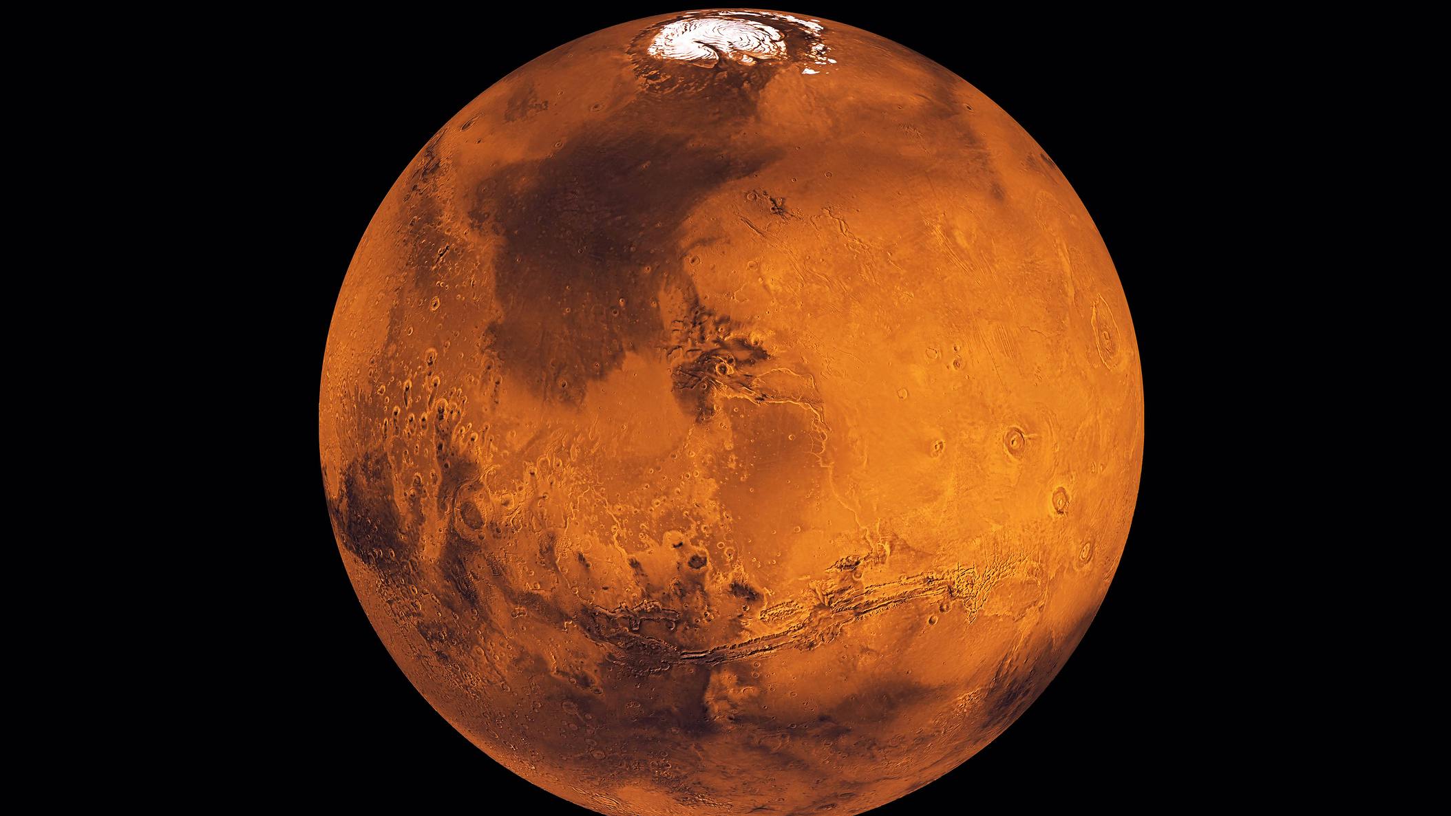 Mars, bright orange, floating through space.