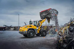 Liebherr L546 wheel loader lifting garbage.