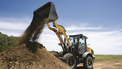 New Holland D-Series W80 compact wheel loader dumping dirt.