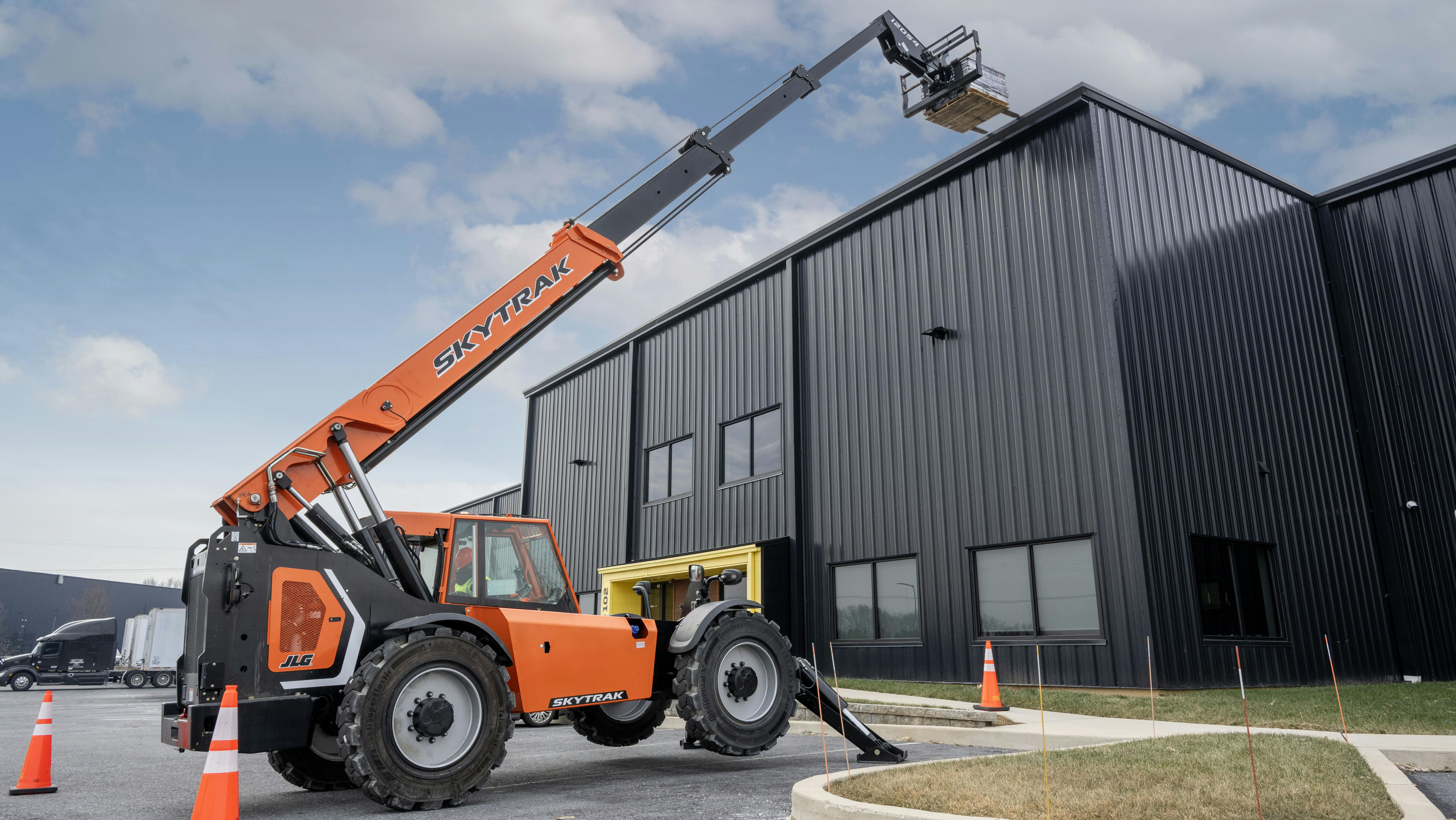 JLG SkyTrak 12054 telehandler lifting pallets to a roof.