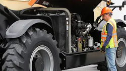 JLG telehandler maintenance. Worker looking in an engine bay.