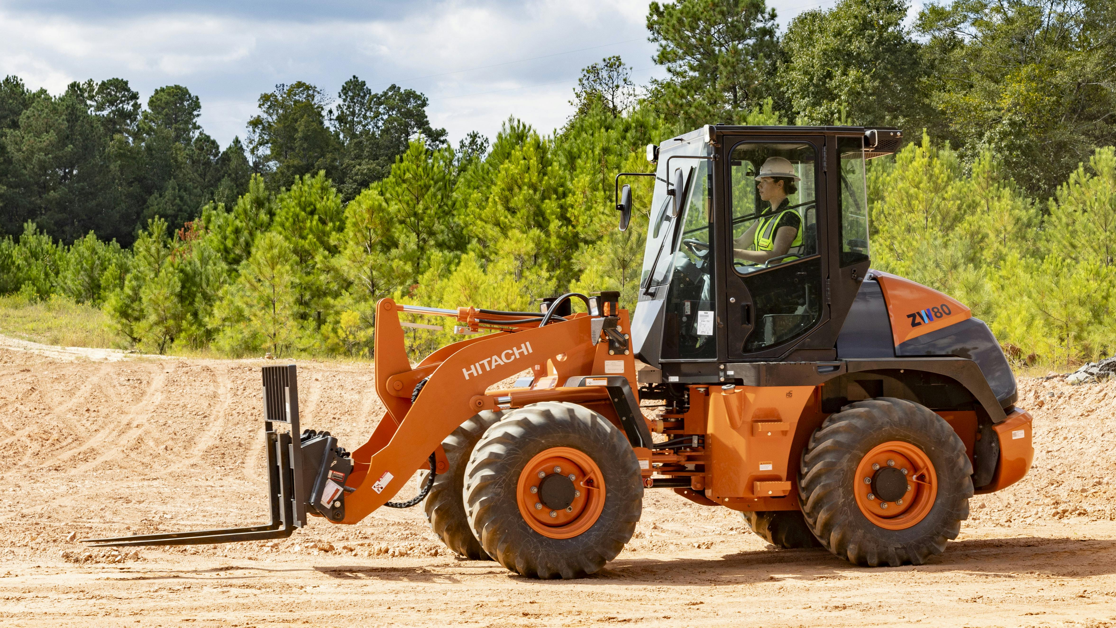 Hitachi 804 compact wheel loader with pallet fork attachments.