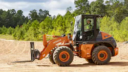 Hitachi 804 compact wheel loader with pallet fork attachments.