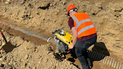 Worker compacting trench
