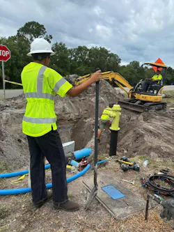 Pipeline workers, excavator