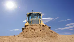 dirt dozer with the sun in the background