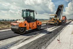 The paving train: A compaction machine follows an asphalt paver.