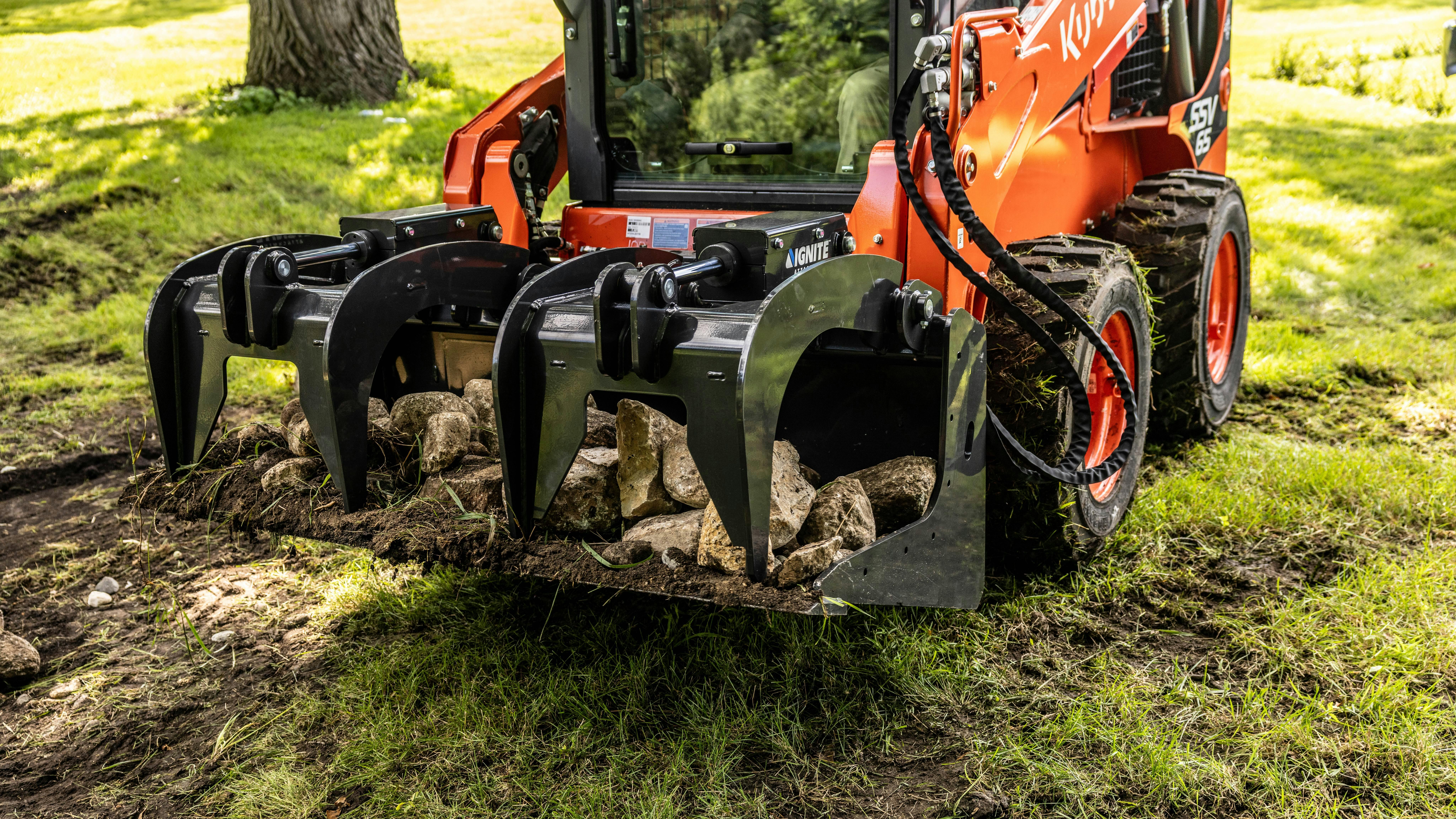 Ignite Attachment bucket grapple holding logs. and rocks.