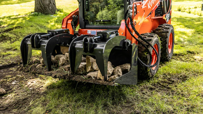 Ignite Attachment bucket grapple holding logs. and rocks.