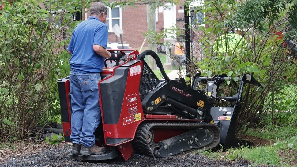 ARA Toro Community Impact Event in Baltimore. A man operates a Toro Dingo, cleaning up brush.
