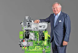 JCB Chairman Lord Anthony Bamford standing next to a JCB hydrogen combustion engine.