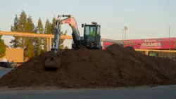 A Bobcat excavator sculpts a BMX track at an XGL competition.