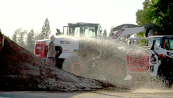 Make it rain! Bobcat machines work the course.