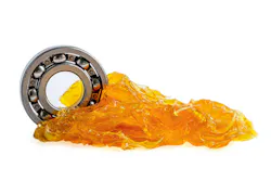Lubricants touch a gear on a white background.