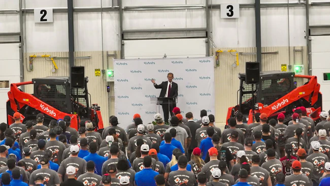 Speaking before a crowd of employees, David Disberger, President and CEO, Great Plains Manufacturing, is flanked by two SVL75-3 compact track loaders during today's celebration event.