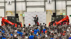 Speaking before a crowd of employees, David Disberger, President and CEO, Great Plains Manufacturing, is flanked by two SVL75-3 compact track loaders during today's celebration event.
