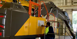 A Volvo CE employee adds a product sticker to an EC230 Excavator on the production line at the Shippensburg facility.