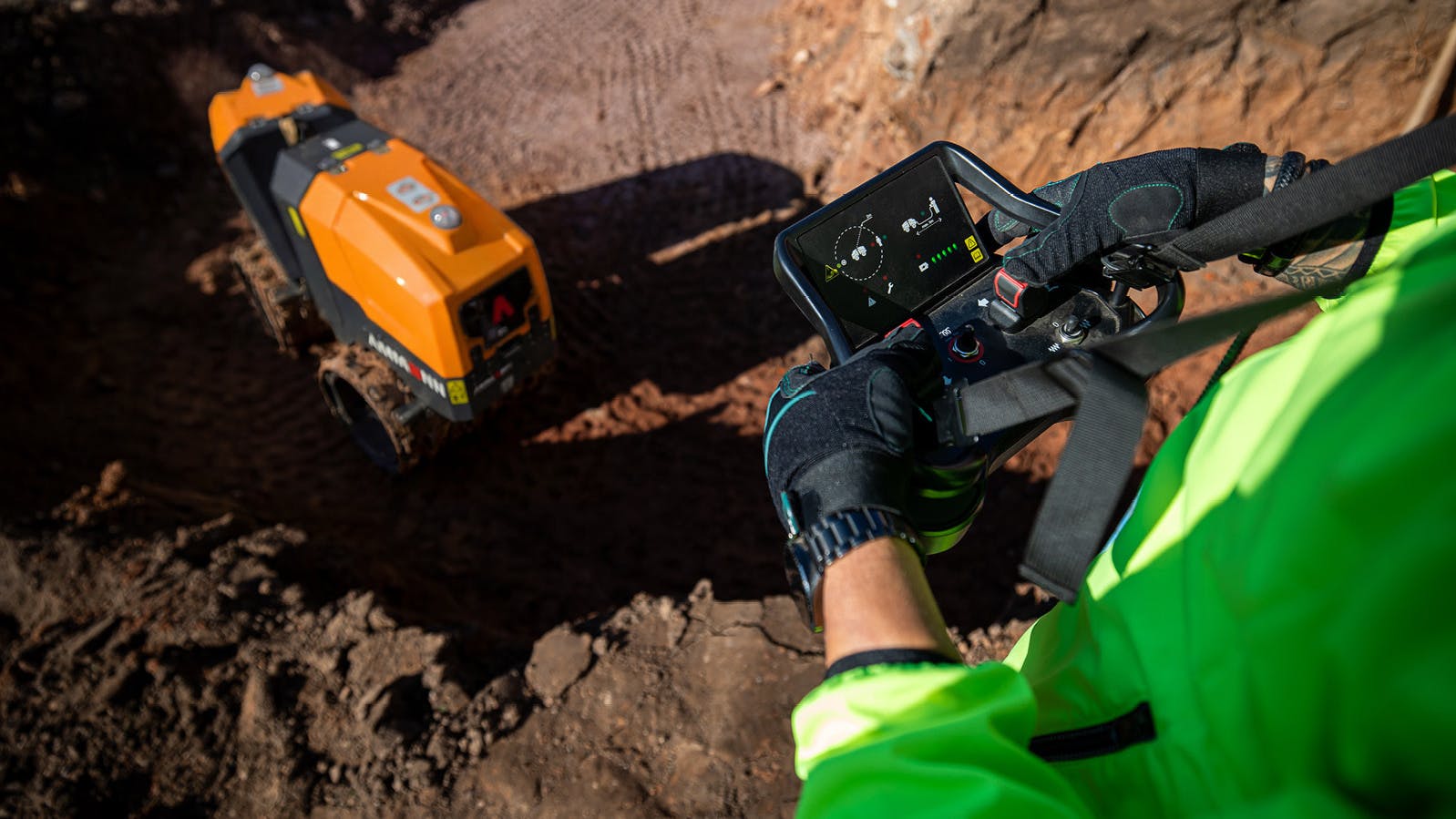 Ammann remote-control trench roller. Operator controls it from above with a remote.