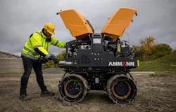 Ammann remote-control trench roller. A mechanic inspects the roller. Its hoods are open.
