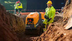 Ammann remote-control trench roller. An operator walks with1 the roller in a trench.