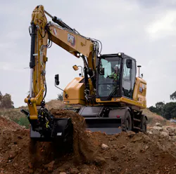 Caterpillar M319 wheeled excavator, digging in the dirt.