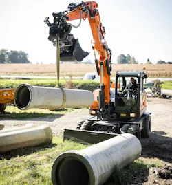 DEVELON's DX100W-7 wheeled excavator picks up pipe.