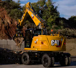 Caterpillar M319 wheeled excavator, picking up debris with a grapple.