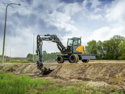 Hyundai HW100A wheeled excavator digging by a road.