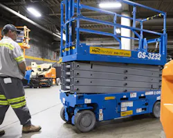 Herc Rentals scissor lift being operated by a worker.