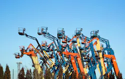 Boom lifts with raised platforms are on-site on for the equipment for rent.
