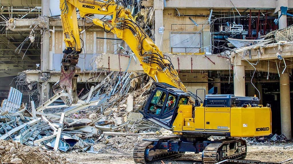 KOBELCO SK650DLC-11 demo excavator with metal shears, tearing apart a building.