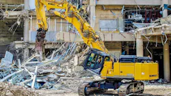 KOBELCO SK650DLC-11 demo excavator with metal shears, tearing apart a building.