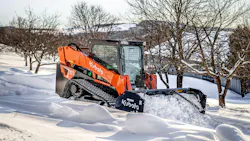 Kubota SVL97-3 compact track loader with a snow pusher attachment, cleaning up snow.
