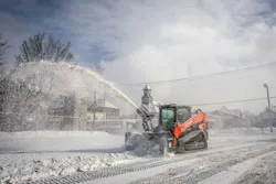 Kubota SVL97-3 compact track loader using a snowblower attachment.
