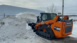 DEVELON DTL35 compact track loader with a snowblower, digging into a pile.