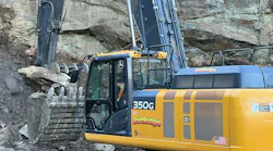 Excavator bucket with thumb handling rock